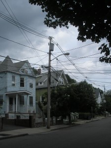 a bunch of power lines criss-crossing in the air above a street